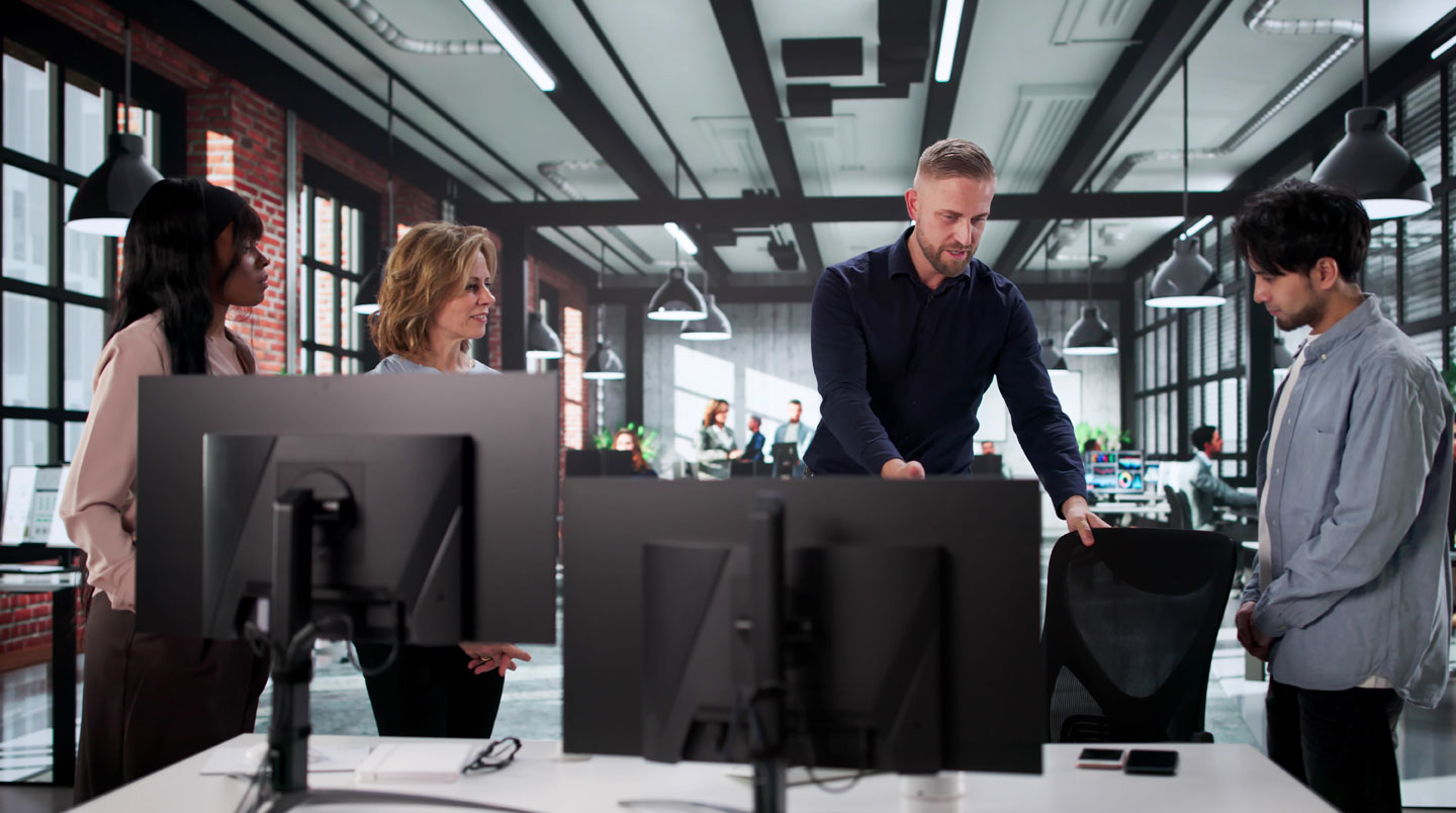 Une responsable RH et un conseiller en aménagement discutent d'un plan d'agencement de bureau ergonomique dans un showroom de mobilier professionnel